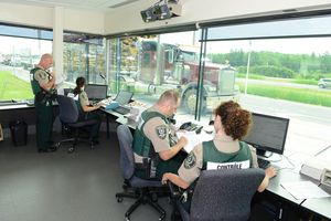 Photo de quatre contrôleurs routiers à l'intérieur d'un poste de contrôle.