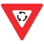 Panneau de signalisation rouge en forme de triangle de type «&nbsp;Cédez le passage&nbsp;» contenant 3 flèches en rond pour illustrer un carrefour giratoire.
