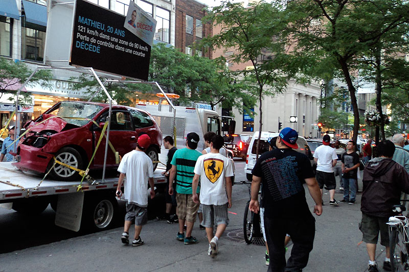 Photo of people in front of an accident-damaged vehicle taken during the field operation at UQAM, in Montréal